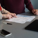 Two people reviewing documents at a table.